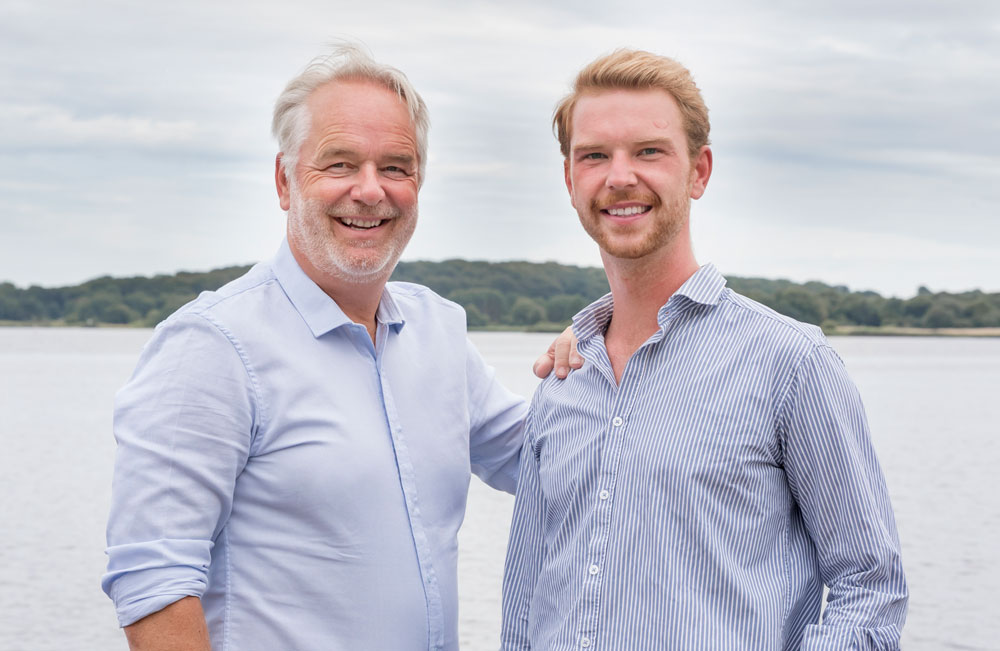 Finanzierungsberater Stefan Erdmann und Jannes Erdmann im Portrait vor der Schlei